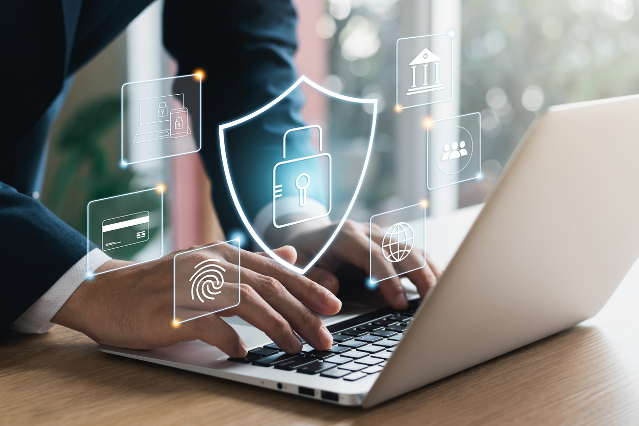 Person typing on a laptop with cybersecurity icons, including a lock, fingerprint, and globe, illustrating digital security in business technology solutions.